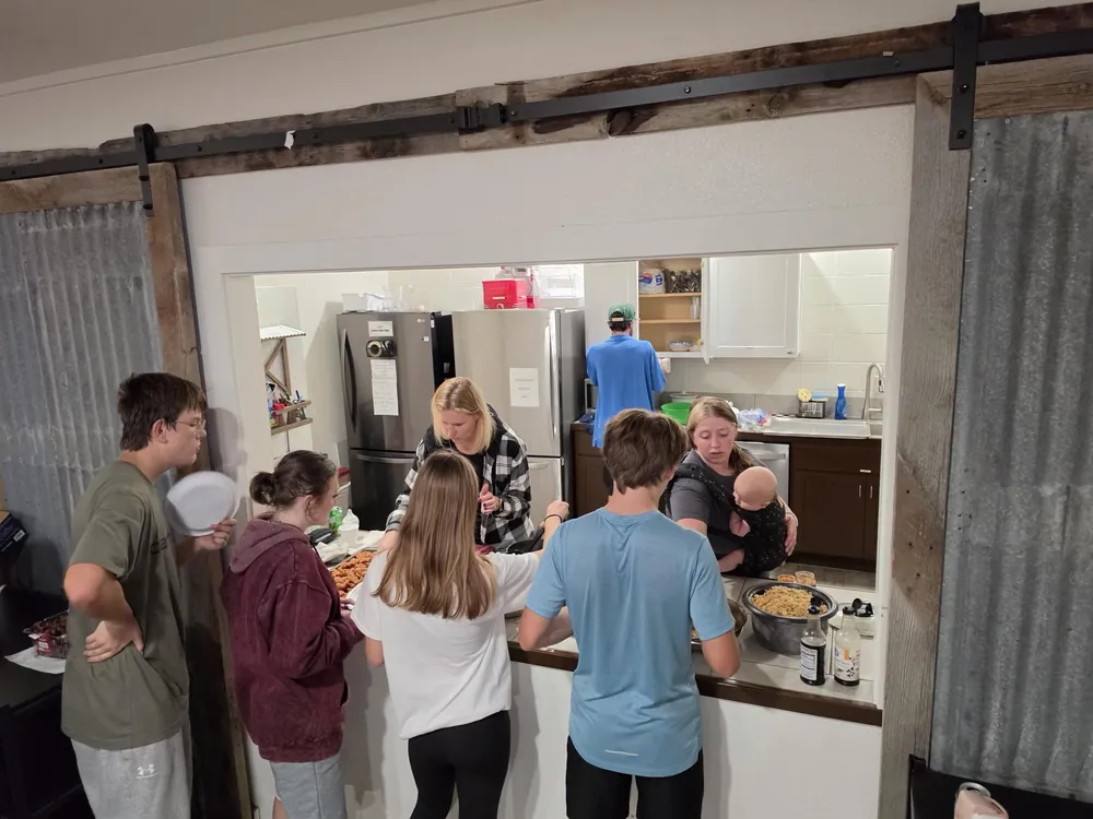 Students and leaders serving dinner in the kitchen at The Refuge